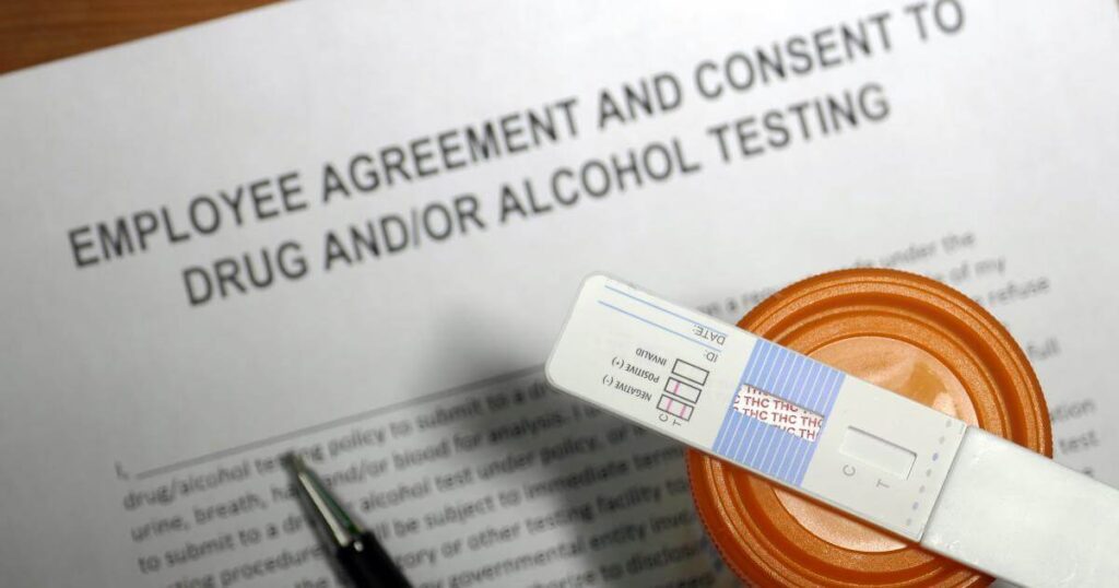 rapid oral swab drug test resting on an employee drug and alcohol testing consent form