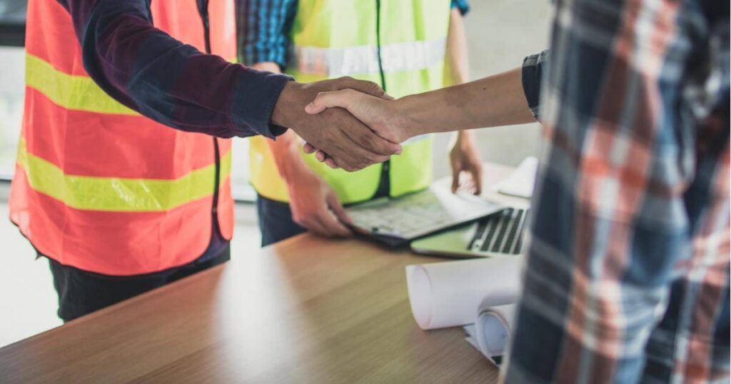 construction foreman shaking hands with general labor worker