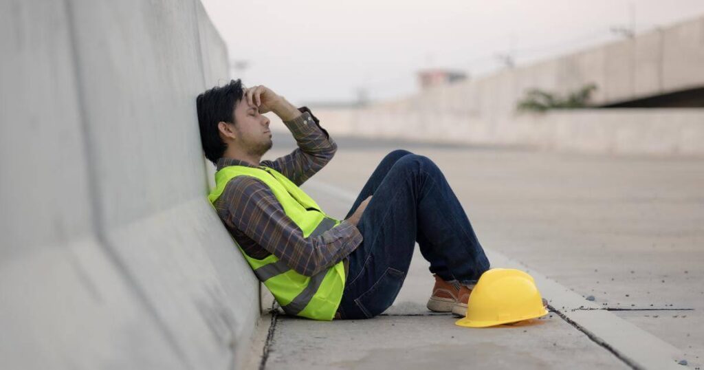 Construction worker waiting outside a jobsite, illustrating transportation barriers in construction staffing