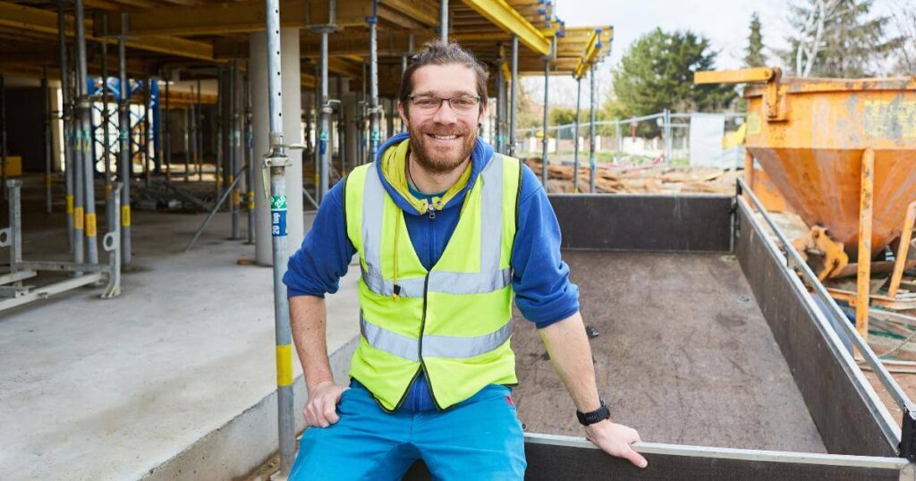 Experienced construction worker in safety vest on an Oregon job site, placed through construction staffing support