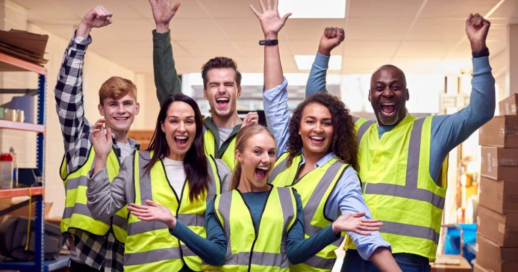 group of workers in safety vests cheering