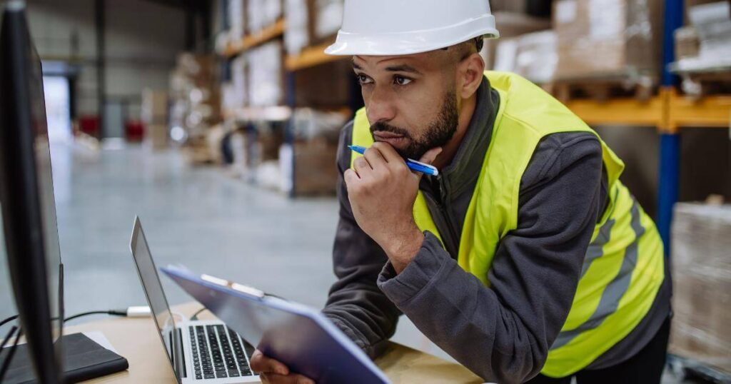 warehouse manager looking at laptop